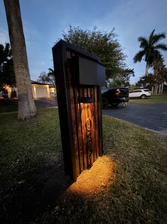 a phone booth sitting on the side of a road next to a tree and grass field