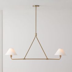 a light fixture with three lamps hanging from it's sides in a white room