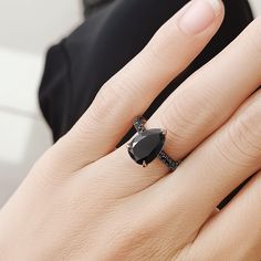 a woman's hand with a black diamond ring on it