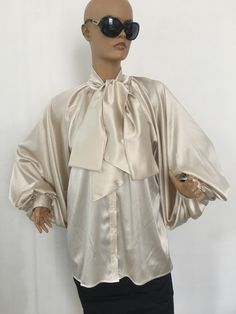 "Amazing and extravagant silk blouse with bow tie collar. Rich puffy sleeves. Elegant and extravagant, perfect for your special occasions. SIZE S - US 6, UK 8, EU 36 bust: bust around 34.5\"/90cm Waist: waist around 27.5\"/70cm Hips: hips around 34.5\"/90cm SIZE M - US 8, UK 10, EU 38 bust: bust around 37.5\"/95cm Waist: waist around 29.5\"/75cm Hips: hips around 37.5\"/95cm SIZE L - US 10, UK 12, EU 40 bust: bust around 39.5\"/100cm Waist: waist around 31.5\"/80cm Hips: hips around 39.5\"/100cm Silk Tie Neck Blouse For Formal Occasions, Formal Silk Tie-neck Blouse, Silk Cream Evening Blouse, Cream Silk Evening Blouse, Cream Silk Blouse For Evening, Formal Silk Tie Neck Blouse, Elegant Evening Top With Bow, Feminine Silk Tie Neck Blouse, Elegant Tie Neck Blouse With Tie Sleeves