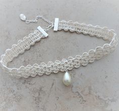 "A braided rayon ivory trim is accented with a wire wrapped tear drop pearl bead.   Braid is crimped and linked with a silver extension chain with a wire wrapped silver bead dangle. The choker closes at 13 1/2\" on first link and the extension chain allows adjustable sizing to 15 1/2\". There is a silver hook closure for adjustable length. if you need a different length, just send a message with your order. All of my jewelry items come boxed and ribbon tied and tagged for easy gifting.  This cho Handmade Adjustable Cream Pearl Necklace, Adjustable Handmade Cream Pearl Necklace, Adjustable Cream Pearl Jewelry, Adjustable Cream Beaded Pearl Necklace, Adjustable Cream Pearl Necklace, Adjustable Cream Choker, Adjustable Cream Pearl Necklace Gift, Adjustable Cream Pearl Necklace For Gift, Bead Choker Necklace