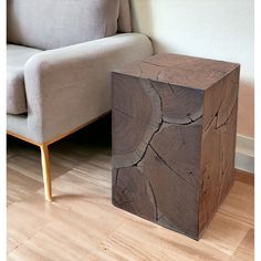 a wooden box sitting on top of a hard wood floor next to a chair and couch