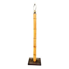 a tall wooden pole with a metal hook on it's end and a white background