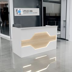 the reception desk is white and has an illuminated sign above it that reads rcs