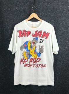 a white rap jam t - shirt hanging on a wall