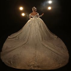 a woman in a wedding dress with lights behind her