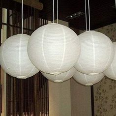 five white paper lanterns hanging from the ceiling