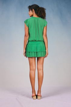 Done in a verdant shade, this short-sleeve mini dress ties up at the neckline and cinches in at the waist before falling to a thigh-skimming tiered hem with crisp, raw edges. The perfect one-and-done number for date night - not to mention one of Current Air's most popular dress. •V-neckline with tie •Relaxed fit •Ruffle trim •Pleated cap sleeves •Elasticized waist •Tiered pleated skirt •Raw edges Item number 1990061-1100% Polyester Dry clean Imported Green V-neck Dress With Pleated Waist, Summer Tiered Dress With Short Sleeves, Green Mini Dress With Ruffle Hem, Casual Kelly Green Summer Dress, Green Ruffled Mini Dress, Green Ruffled Tiered Mini Dress, Green Tiered Ruffle Mini Dress, Green Tiered Skirt Mini Dress With Ruffles, Green Knee-length Mini Dress With Ruffle Hem