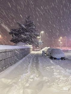 a snow covered street with cars parked on it