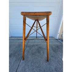 an old wooden stool sitting in front of a garage door