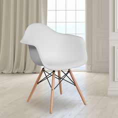 a white chair sitting in front of a window next to a wooden floor and wall