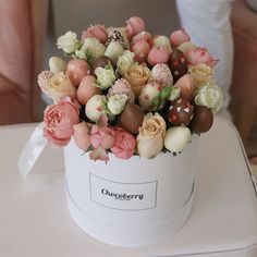 a bouquet of flowers in a white box sitting on a table with the name choccberry written on it