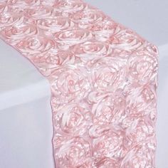 a pink table runner with roses on it