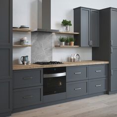 a kitchen with gray cabinets and wooden counter tops