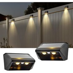 two solar powered lights on the side of a fence