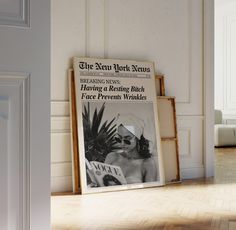 an advertisement for the new york news hangs in front of a white room with wood flooring