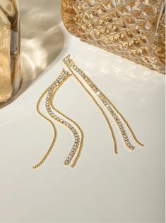 Sparkling Streamers: Dangle Earrings for Every Occasion Step into a world of timeless elegance where delicate chains adorned with sparkling rhinestones and cascading down to a radiant teardrop crystal transform your everyday into a fashion runway. These exquisite earrings, crafted from high-quality, 18K gold-plated stainless steel, are the epitome of grace and sophistication. Embrace the allure of Sparkling Streamers, a name that perfectly captures the essence of these captivating earrings.Envis Glamorous Long Drop Sparkling Jewelry, Long Drop Rhinestone Party Jewelry, Party Jewelry With Long Drop Rhinestones, Party Jewelry With Rhinestones In Long Drop Shape, Party Long Drop Rhinestone Jewelry, Long Drop Crystal Jewelry For Evening, Glamorous Long Drop Jewelry With Sparkling Stones, Evening Long Drop Linear Earrings With Adjustable Chain, Crystal Long Drop Linear Earrings