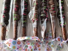 chocolate covered donuts wrapped in clear cellophane and tied with colorful ribbon on table