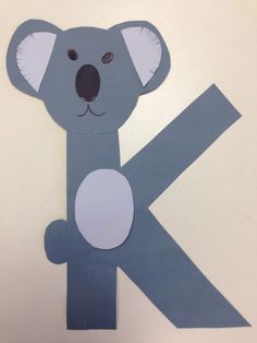 a paper koala cut out to look like it is holding the letter k in its paws