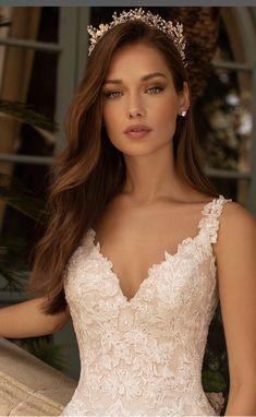 a woman in a wedding dress with a tiara on her head and long hair