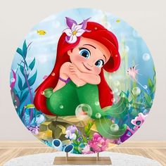 the little mermaid is sitting in front of an aquarium scene with bubbles and flowers on it