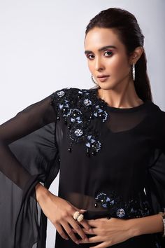 Black overlay top with floral embroidery highlighted with bead work. Paired with a crop top and pant. - Aza Fashions Black Embellished Georgette Blouse, Elegant Hand Embellished Georgette Top, Designer Hand Embellished Party Tops, Elegant Embroidered Top With Festive Sleeves, Elegant Embroidered Top With Embroidered Sleeves For Festive Occasions, Hand Embellished Tops For Festive Party Wear, Elegant Sequined Tops For Designer Wear, Elegant Festive Top With Embroidered Sleeves, Festive Elegant Embroidered Sleeves Top