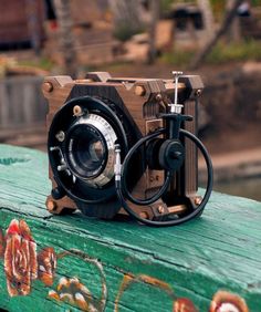 an old camera sitting on top of a wooden table