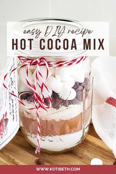 an easy recipe for hot cocoa mix in a mason jar with candy canes and marshmallows