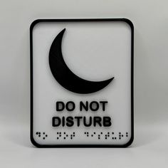 a sign that says do not disturb with a crescent and stars on the bottom in black