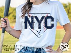 a woman holding a baseball bat and wearing a t - shirt with the nyc logo on it