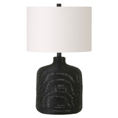 a black table lamp with a white shade on the base and a light in front of it