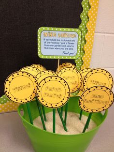 a green bucket filled with sand next to a chalkboard and some stickers on it