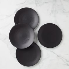 three black plates sitting on top of a white counter