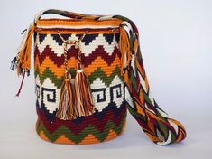 a multicolored bag with tassels and fringe on the handle is shown