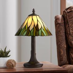 a lamp sitting on top of a wooden table next to a potted succulent