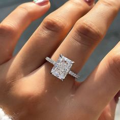 a woman's hand with a diamond ring on it and two diamonds in the middle