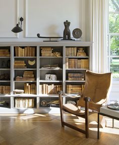 an old chair sits in front of a bookshelf