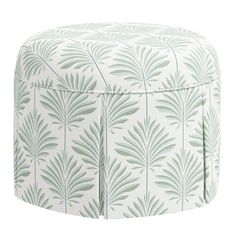 a white and green ottoman with leaves on it