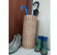 a basket with an umbrella and rubber boots next to it