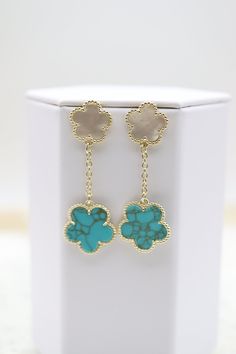 The Gold Plated Mother of Pearl and Turquoise Five Leaf Flower Petal Pendant Earrings feature a stunning design with five petals, each inlaid with iridescent mother of pearl and turquoise, radiating from a central gold-plated core. These exquisite earrings add a touch of sophistication and natural beauty to any ensemble, perfect for enhancing special occasion outfits. Length: 51.9 mm Width: 14.9 mm; 18.5 mm Closure: Butterfly Earring Backs Material: Brass with 18K Gold Plating with Rhodium Coati Turquoise Jewelry With Flower Charm, Turquoise Dangle Earrings With Flower Charm, Turquoise Flower Charm Jewelry, Turquoise Flower-shaped Jewelry With Flower Charm, Elegant Turquoise Earrings With Flower Charm, Elegant Turquoise Flower Earrings, Turquoise Flower Charm Dangle Jewelry, Turquoise Dangle Jewelry With Flower Charm, Turquoise Earrings With Flower Charm