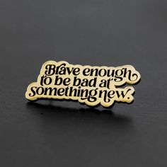 a black and gold pin with the words, have enough to be bad at something new