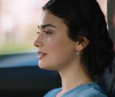 a woman sitting in the back seat of a car with her head turned to the side