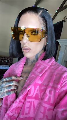 a woman wearing sunglasses and a pink robe