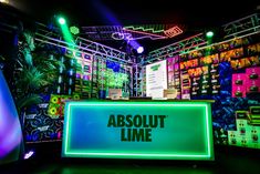 a neon sign that says absolut lime on it in front of colorful lights