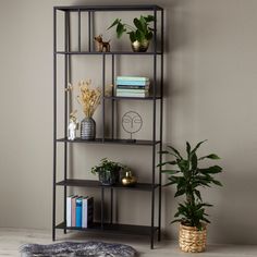 a black shelf with vases and plates on it in the corner of a room