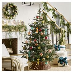 a decorated christmas tree in a basket next to a stair case with wreaths on it