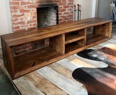 a living room with a brick fireplace and wooden furniture