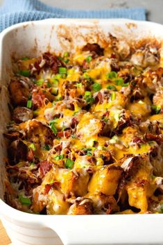 a casserole dish with meat, cheese and green onions