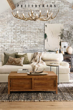 a living room filled with furniture and a large light fixture hanging over the top of it