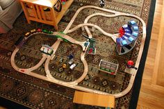 a child's toy train set is on the floor in front of a table